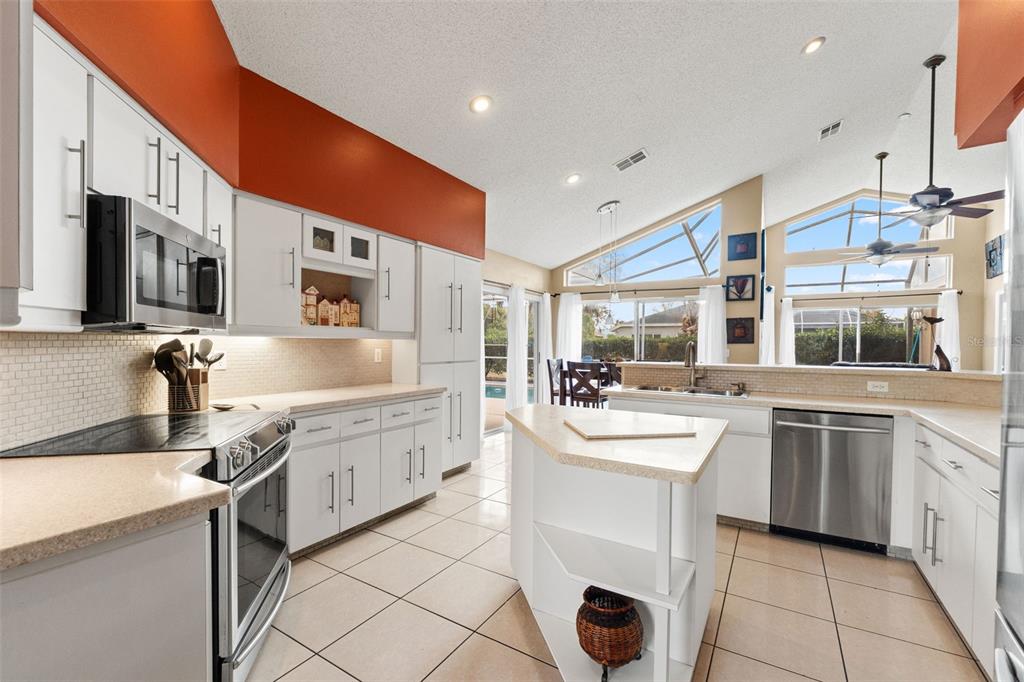 14122 Newcastle Avenue Spring Hill, FL 34609 - Photo 62 of 66 a room with stainless steel appliances kitchen island granite countertop a sink and cabinets