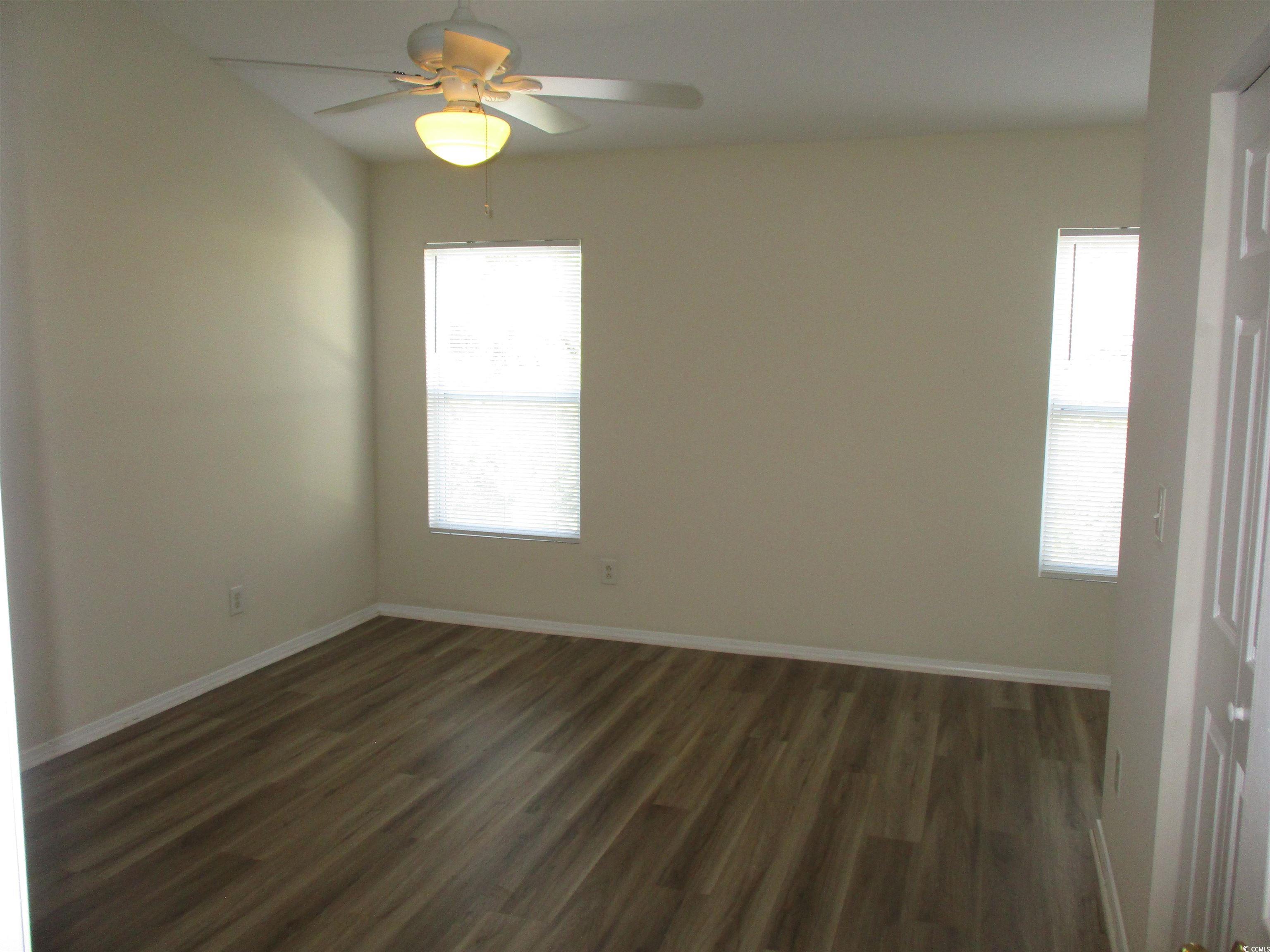 161 Olde Towne Way Myrtle Beach, SC 29588 - Photo 14 of 25 Empty room featuring dark wood-style flooring, plenty of natural light, and ceiling fan