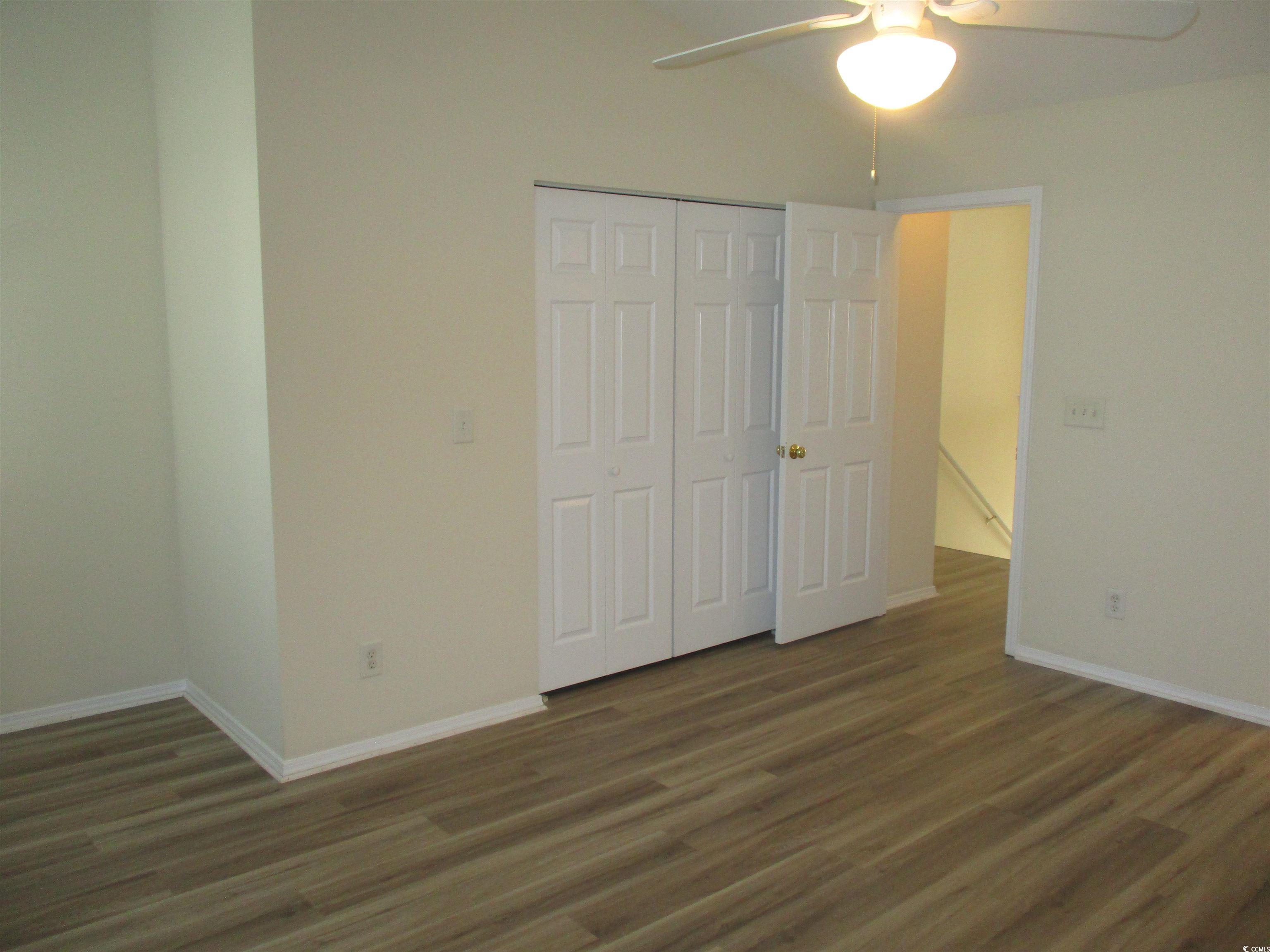 161 Olde Towne Way Myrtle Beach, SC 29588 - Photo 15 of 25 Unfurnished bedroom featuring dark wood-style flooring, a ceiling fan, and a closet