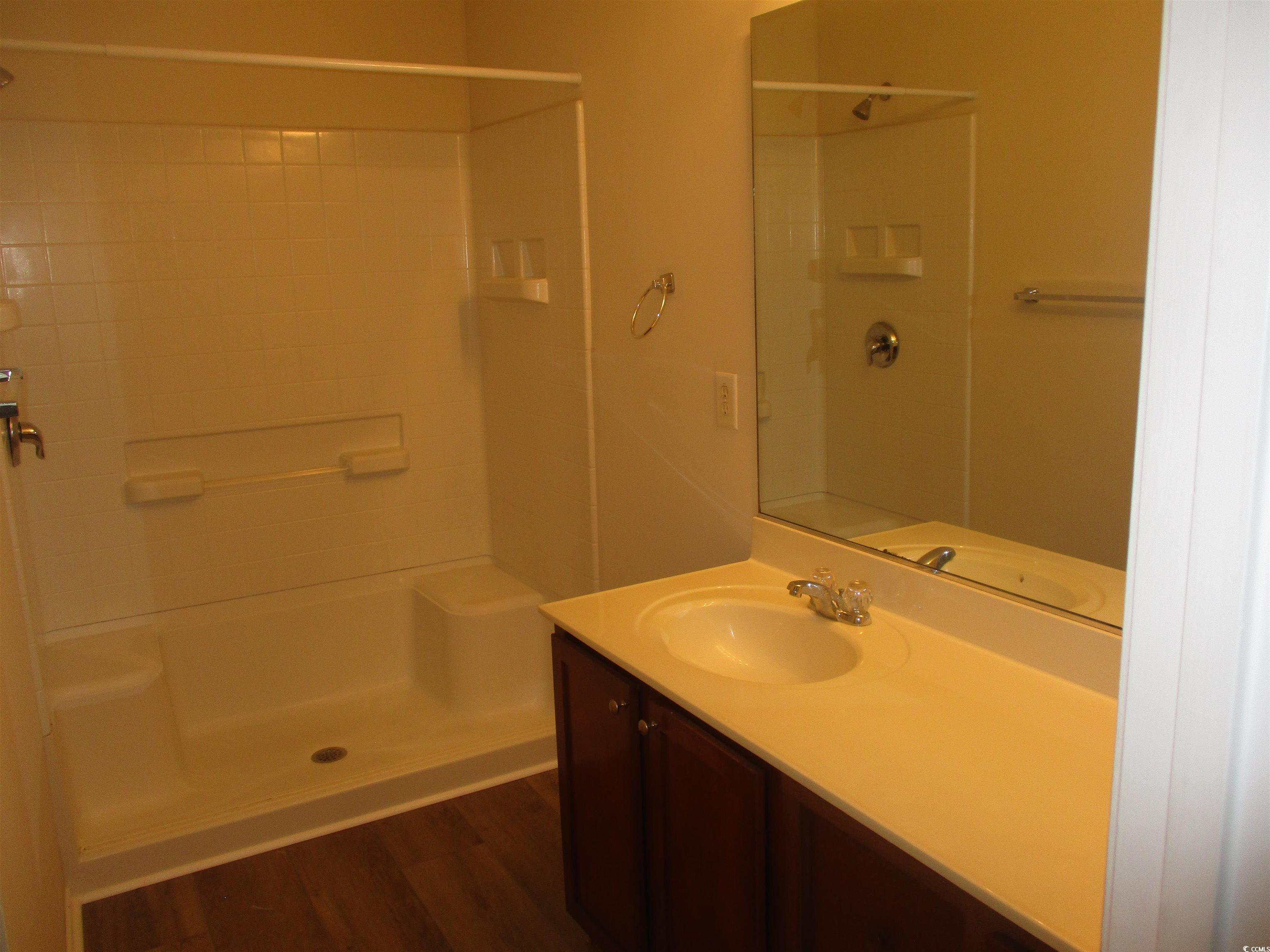 161 Olde Towne Way Myrtle Beach, SC 29588 - Photo 17 of 25 Bathroom with vanity, a stall shower, and dark wood finished floors