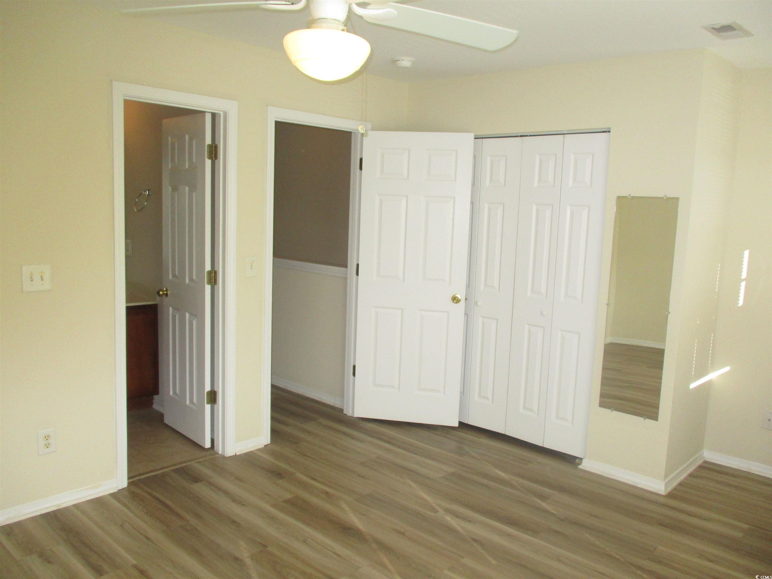 161 Olde Towne Way Myrtle Beach, SC 29588 - Photo 21 of 25 Unfurnished bedroom with wood finished floors, a closet, ceiling fan, and ensuite bath