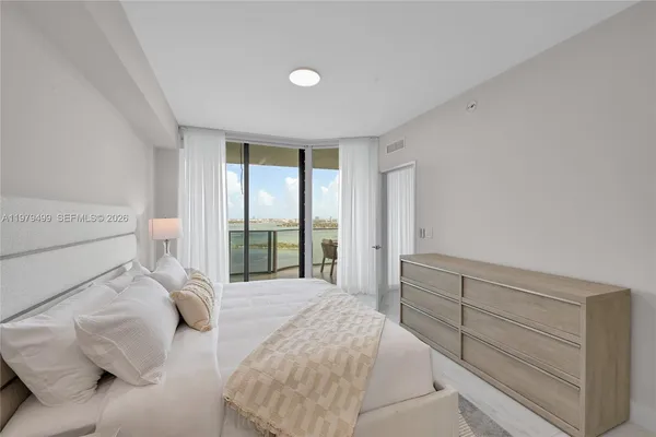 a bedroom with a large bed and a large window