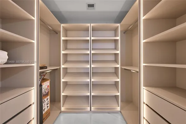 a view of walk in closet with empty racks