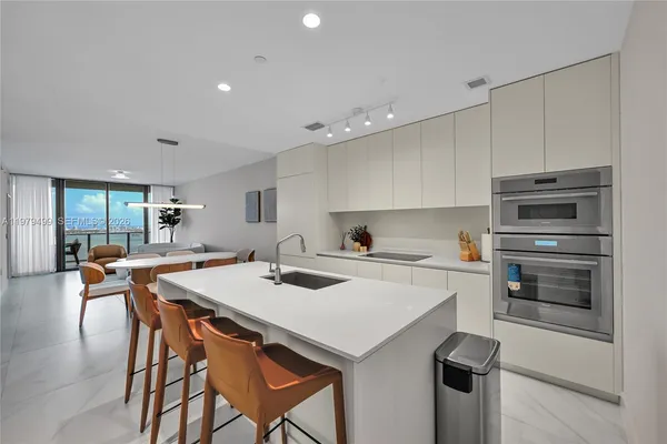 a kitchen with a stove a refrigerator and a dining table