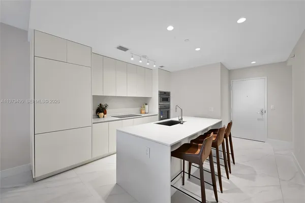 a kitchen with a sink a table and chairs