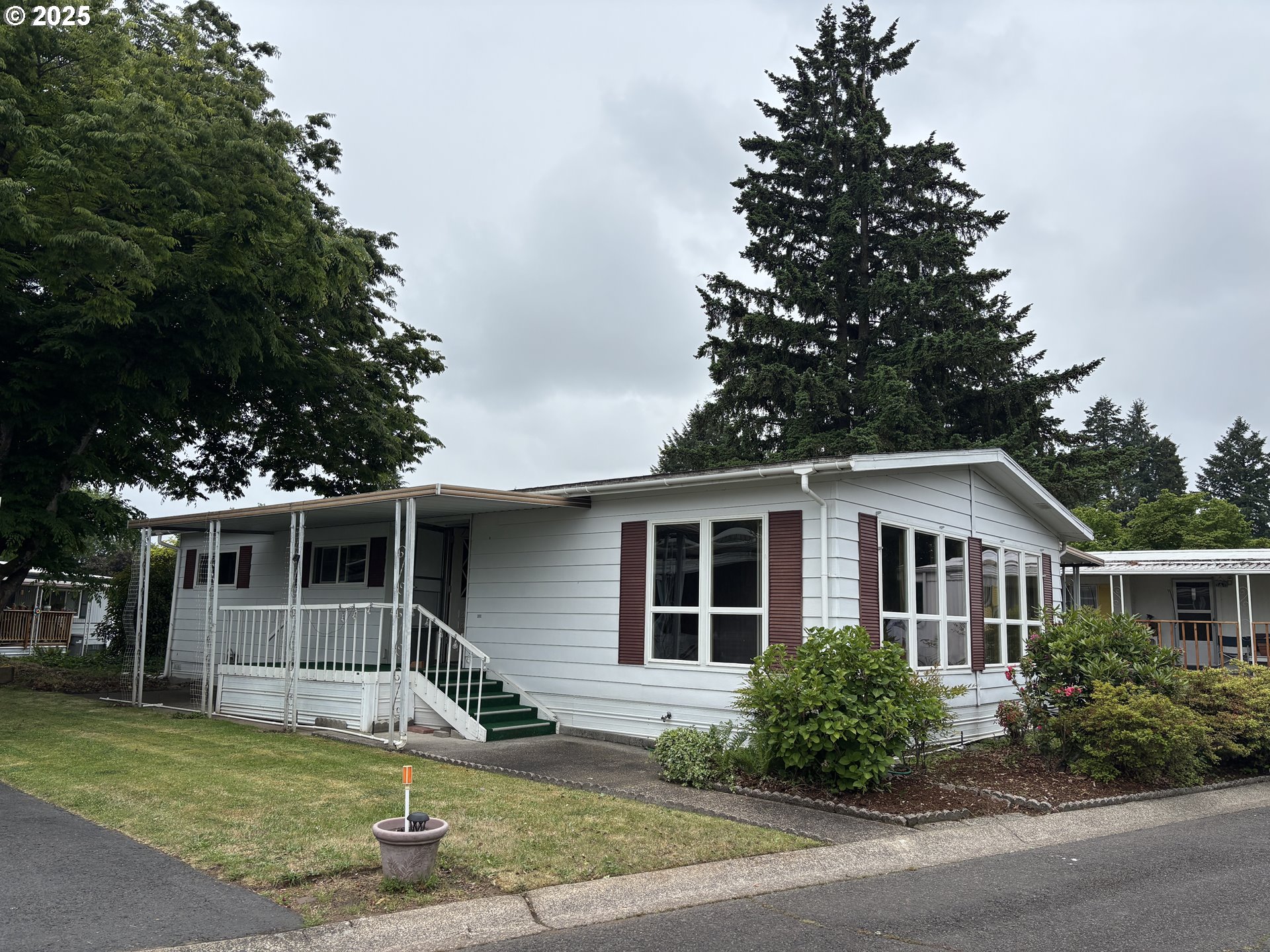 a front view of a house with a garden and plants