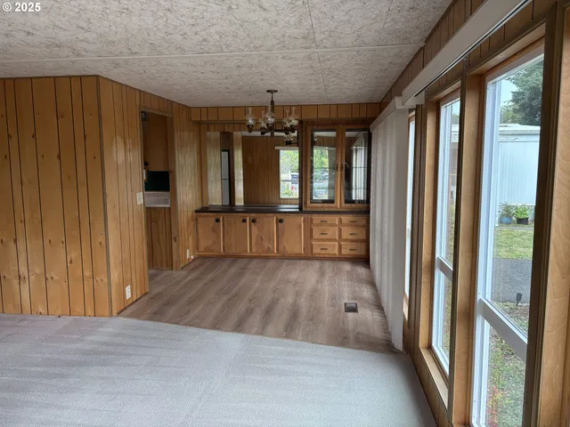 a view of hallway with wooden floor and chandelier