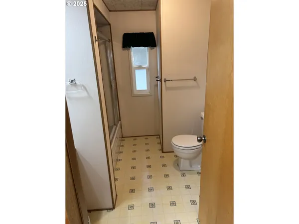 a bathroom with a granite countertop shower and a toilet