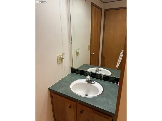 a bathroom with a granite countertop sink and a mirror
