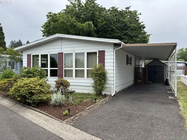 a front view of a house with a yard and potted plants