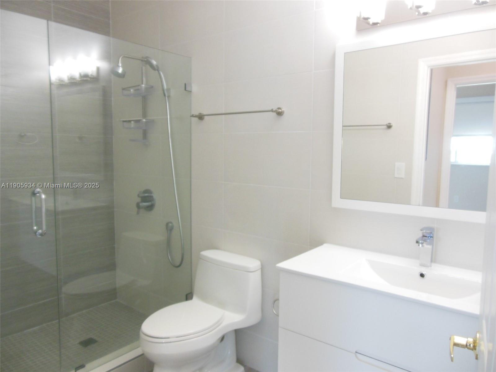 2280 Southwest 32nd Avenue, Unit 406 Miami, FL 33145 - Photo 8 of 8 a bathroom with a shower a sink a toilet and mirror