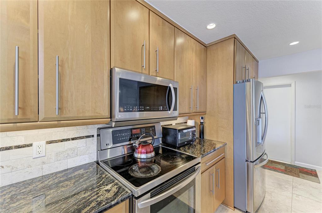258 Surinam Street Punta Gorda, FL 33983 - Photo 16 of 47 a kitchen with stainless steel appliances granite countertop a stove microwave and refrigerator