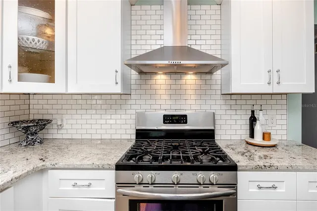 a kitchen with granite countertop white cabinets and window