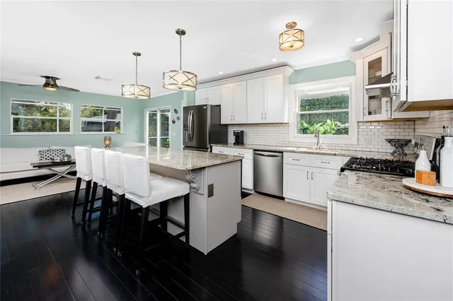 a kitchen with stainless steel appliances white cabinets and a stove a sink