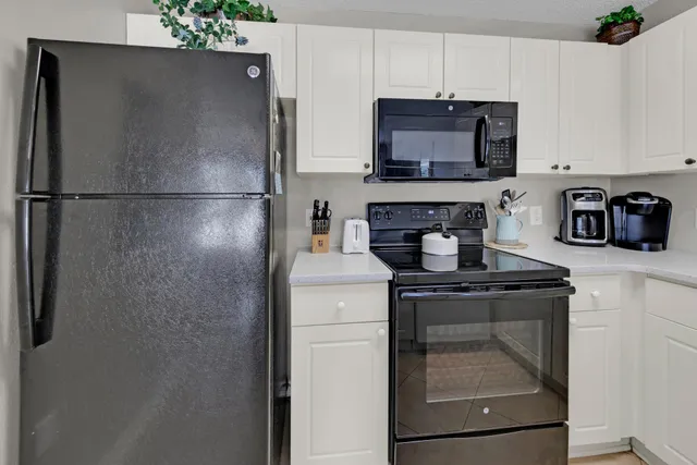 a kitchen with stainless steel appliances granite countertop a refrigerator stove and microwave