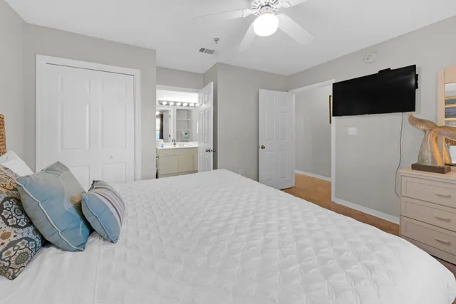 a spacious bedroom with a bed and a flat screen tv