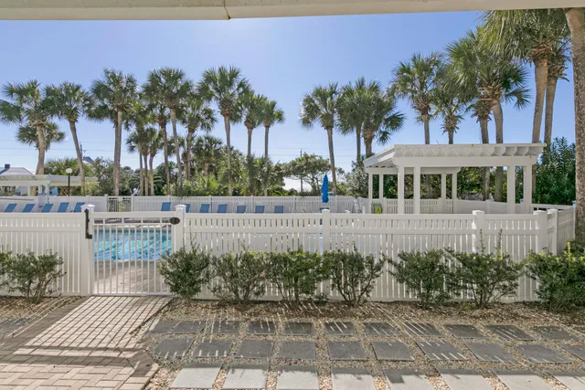 a view of swimming pool with a table and chairs under an umbrella