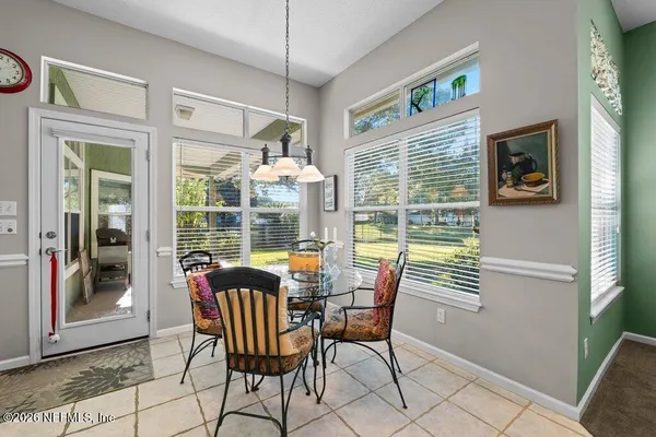 a dining room with furniture a rug and a large window