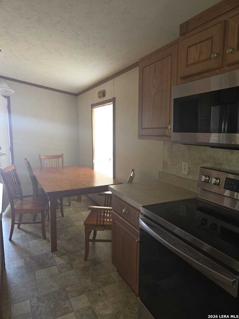 311 East Frio Street Dilley, TX 78017 - Photo 11 of 24 a kitchen that has a sink and a stove