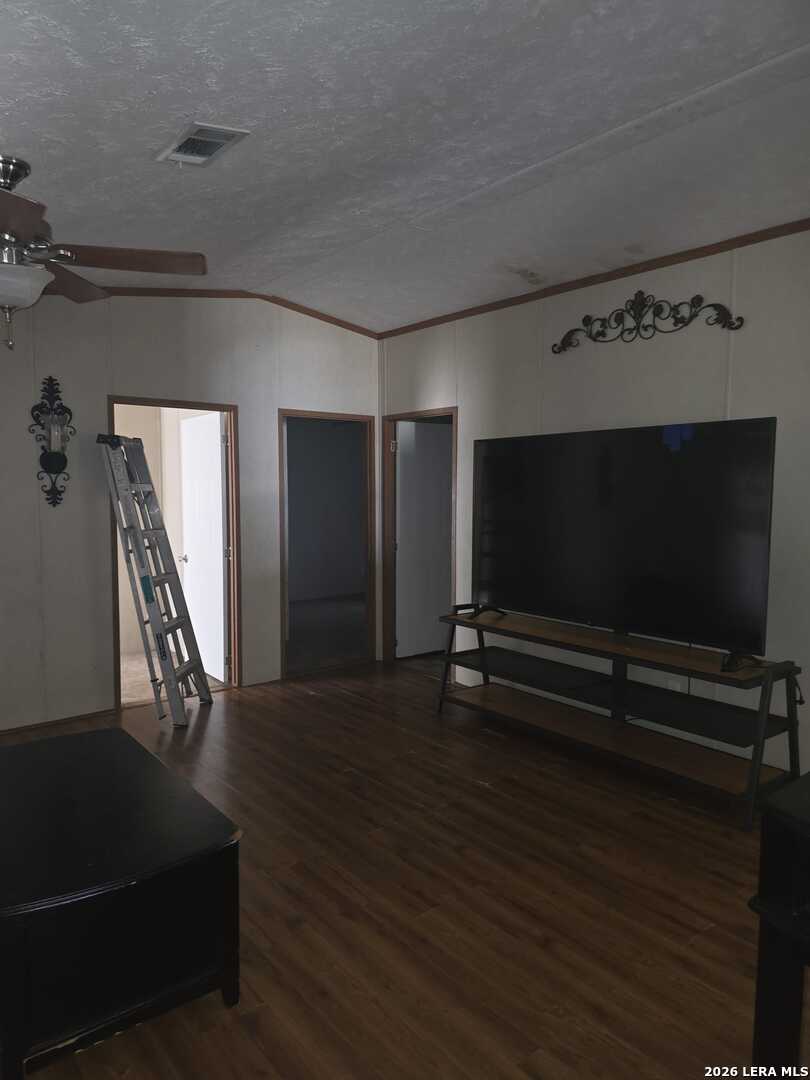 311 East Frio Street Dilley, TX 78017 - Photo 18 of 24 a view of room with window and wooden floor