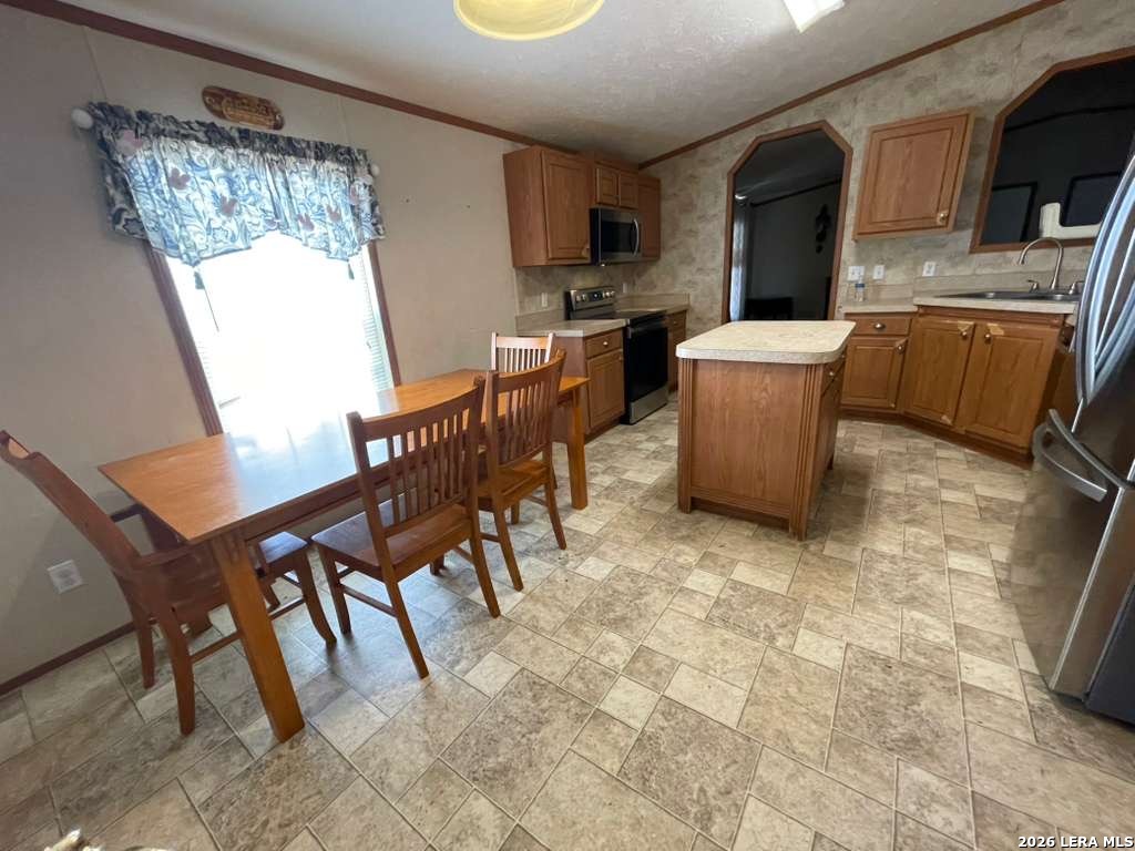 311 East Frio Street Dilley, TX 78017 - Photo 7 of 24 a view of a dining room with furniture a kitchen and chandelier