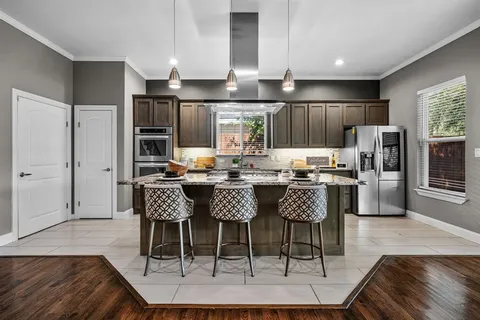 a dining room with stainless steel appliances a dining table chairs and refrigerator