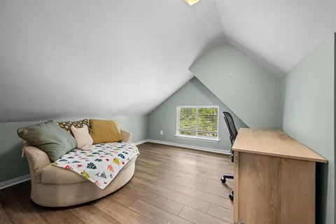 a view of a room with wooden floor and lounge chair