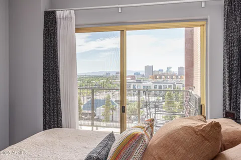 a bedroom with a bed and a large window