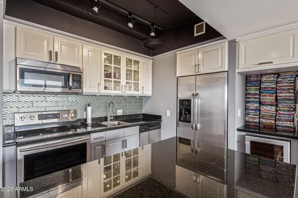 a kitchen with stainless steel appliances granite countertop a stove and a refrigerator