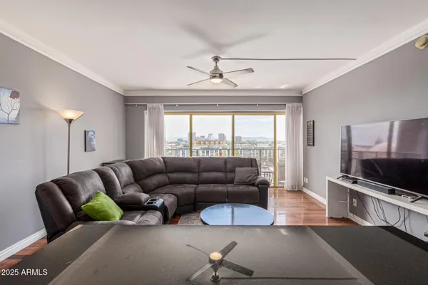 a living room with furniture a flat screen tv and a large window