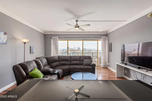a living room with furniture a flat screen tv and a large window