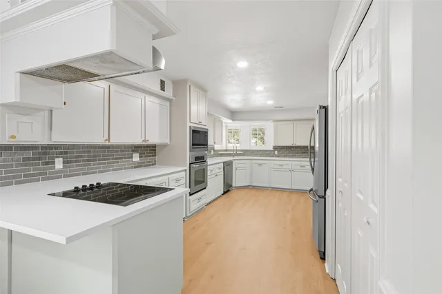 a kitchen with a stove a sink a refrigerator and cabinets