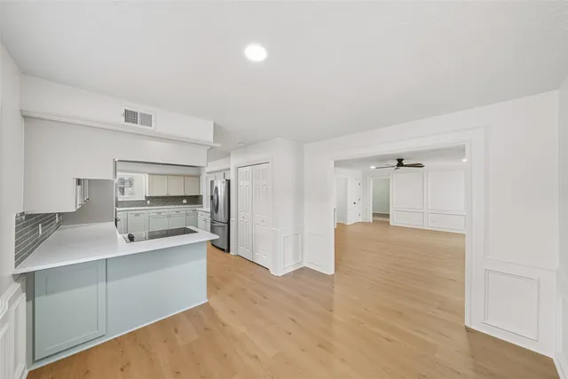 a kitchen with a sink cabinets and wooden floor