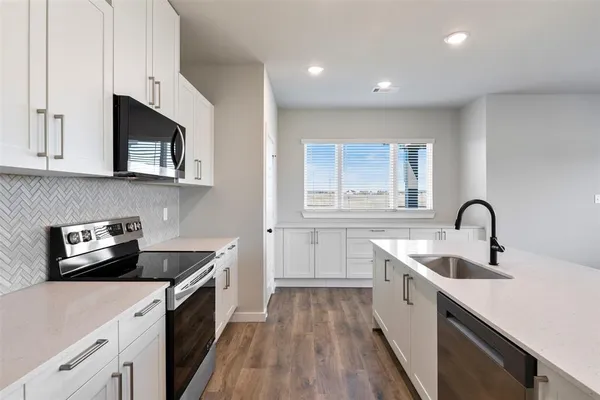 a kitchen that has a sink and a stove in it