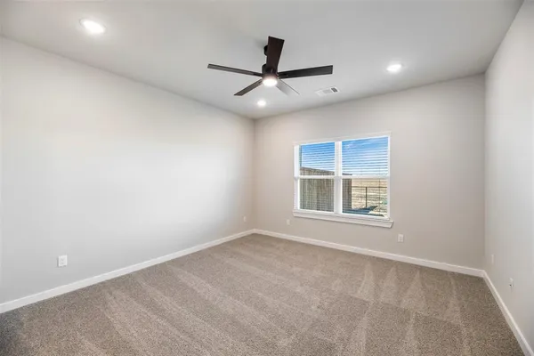 en empty room with windows and ceiling fan