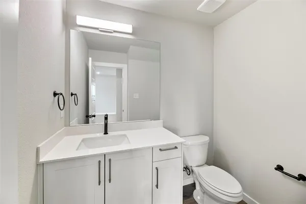 a bathroom with a sink a toilet a mirror and vanity