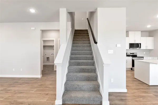 a view of entryway and kitchen with wooden floor