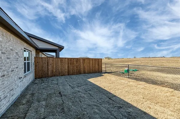 a view of a backyard with wooden fence