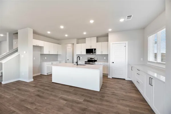 a kitchen with white cabinets and stainless steel appliances