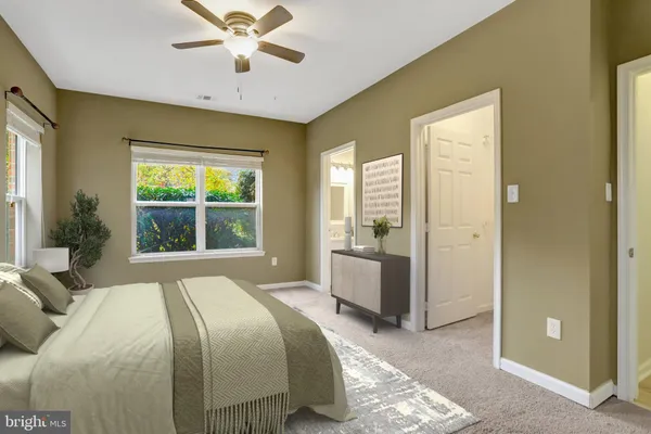 a bedroom with a large bed and a chandelier fan
