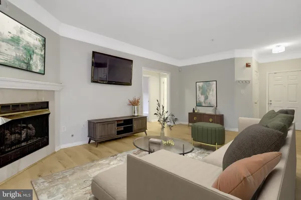 a living room with furniture a flat screen tv and a fireplace