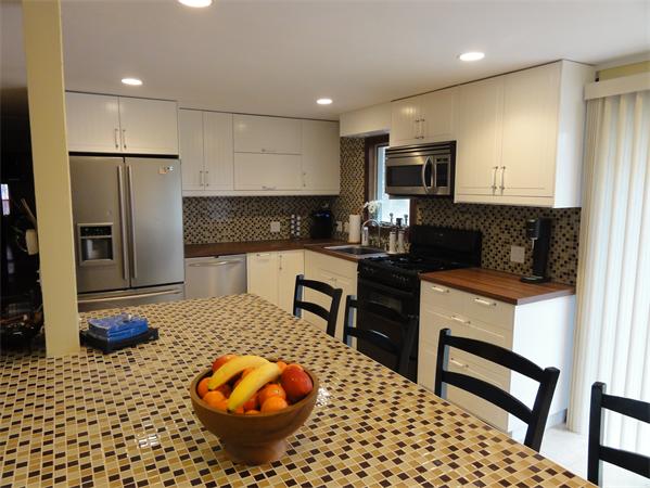 12 Weathervane Road Billerica, MA 01821 - Photo 3 of 30 a kitchen with stainless steel appliances kitchen island granite countertop a refrigerator and a stove top oven