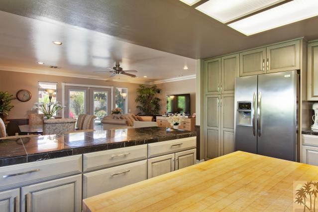 68130 Perlita Road Cathedral City, CA 92234 - Photo 6 of 19 a kitchen with stainless steel appliances kitchen island granite countertop a refrigerator a sink and dishwasher with wooden floor