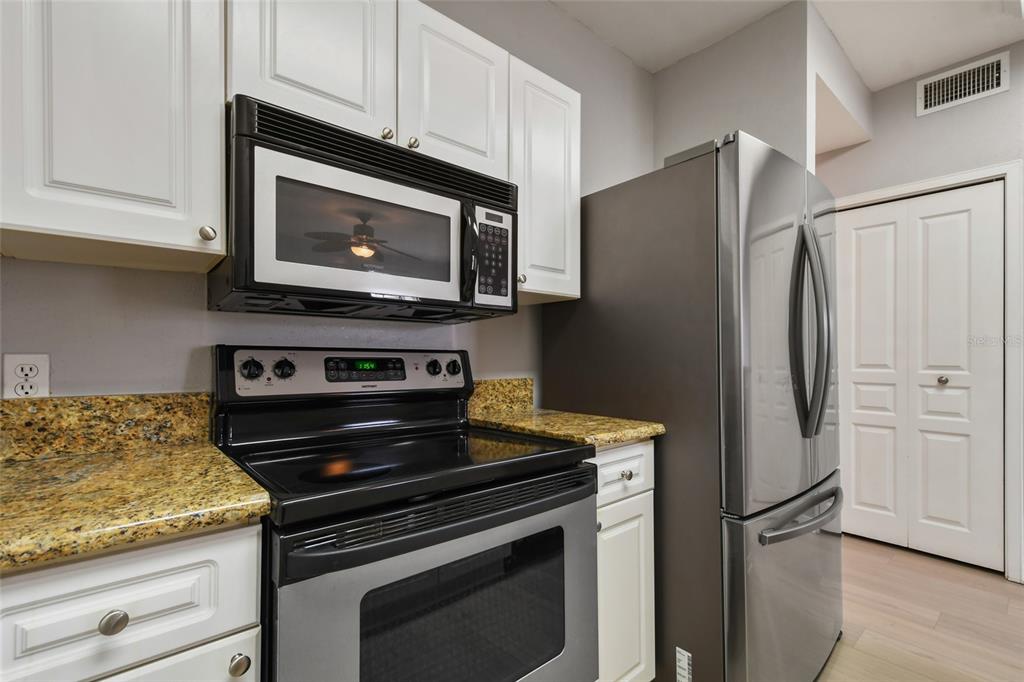 600 Market Street, Unit 340 Celebration, FL 34747 - Photo 12 of 35 a kitchen with stainless steel appliances white cabinets and a stove top oven