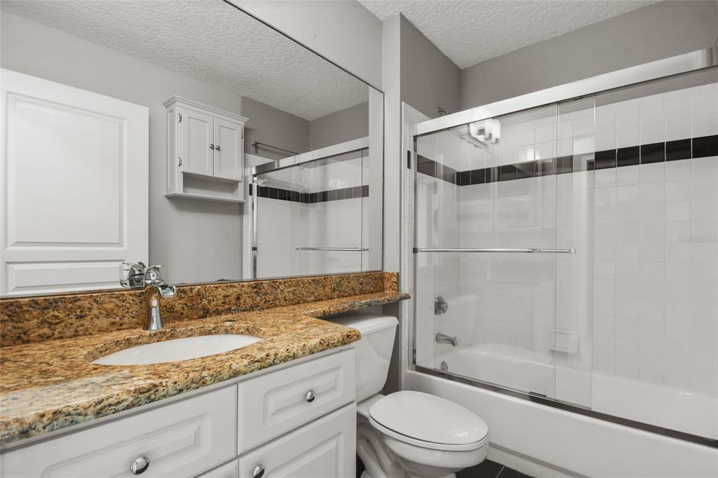 600 Market Street, Unit 340 Celebration, FL 34747 - Photo 6 of 35 a bathroom with a granite countertop sink toilet and shower