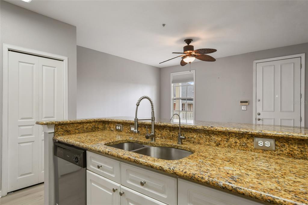 600 Market Street, Unit 340 Celebration, FL 34747 - Photo 8 of 35 a kitchen with sink granite and white cabinets