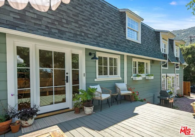 a view of a patio with table and chairs under an umbrella with wooden floor