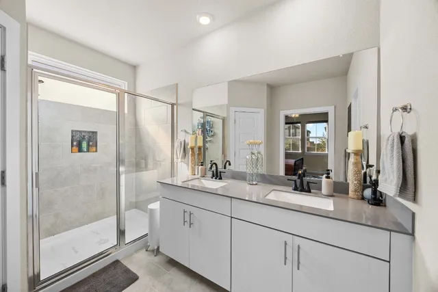 a bathroom with double vanity and a mirror