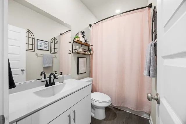 a bathroom with a sink a toilet and shower