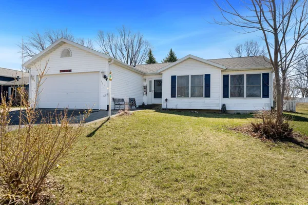 a front view of a house with yard and trees